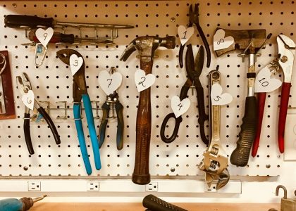 Neatly arranged tools on a pegboard in a well-lit workshop setting.